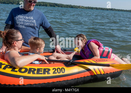 Family enjoying a day on the water in their inflated raft. Clitherall Minnesota MN USA Stock Photo
