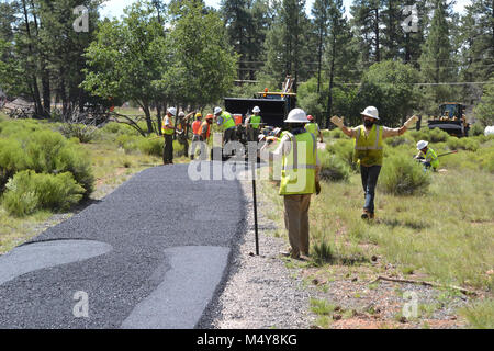 A view of the paving in progress.  Between August 10 to September 10, 2016 the Greenway Trail between the IMAX Theater parking area in Tusayan and Center Road in Grand Canyon National Park will be closed while Grand Canyon's trail crew installs asphalt. The portion of the trail north of Center Road will not be affected.  While the trail closure is in effect, cyclists and hikers may ride the Tusayan shuttle (Purple Route) which is equipped with bicycle carrier racks. The shuttle connects Tusayan with the South Rim Visitor Center, a 20 minute ride each way.  The intent of this project is to comp Stock Photo