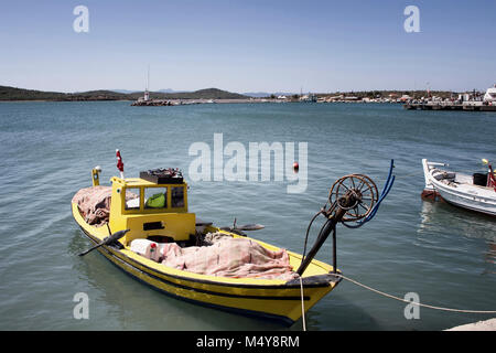 Small, yellow, wooden fishing boat and Aegean sea in Cunda (Alibey) island. Stock Photo