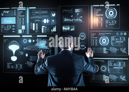 Thoughtful programmer standing and analyzing the information on the screen Stock Photo