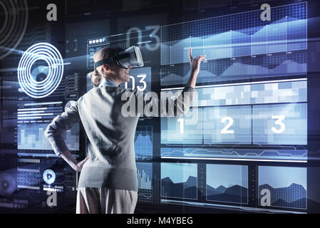 Happy woman smiling while exploring virtual reality at work Stock Photo