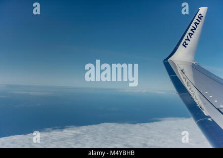 Ryanair, budget airline, Boeing 737 airplane flying in the blue sky. Wing with logo on winglet. Copy space. Stock Photo