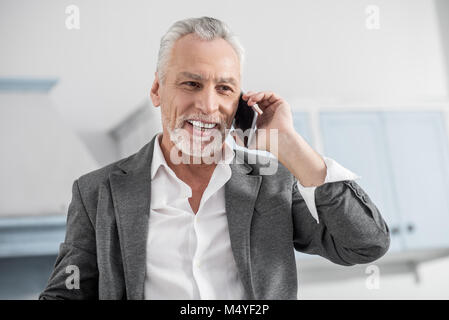 Positive delighted man having pleasant conversation Stock Photo