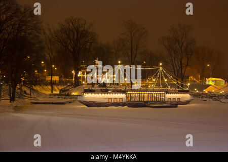 Jelgava Pasta island in winter nignht cafe ship and Holy Trinity Church Tower Stock Photo