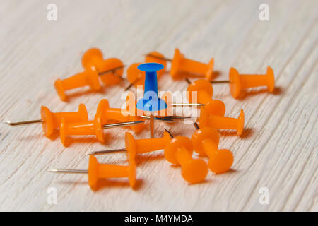 Stationary, Orange, Blue Pushpins Heap on White Wooden Background, Business Leadership Concept. Stock Photo