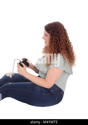 Woman sitting on floor playing her video game Stock Photo