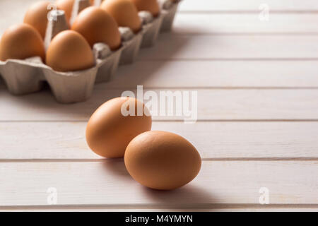 Raw, brown, chicken eggs on wooden white boards. Stock Photo