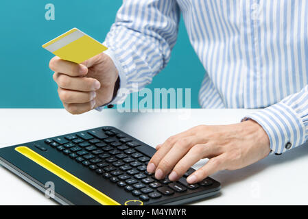 Man hands using keyboard and holding credit card Stock Photo