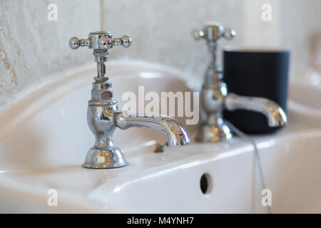 Traditional antique two hole basin taps. Stock Photo
