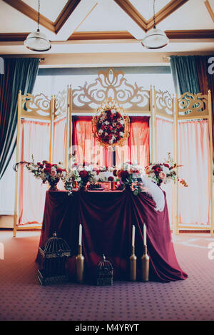 decor of a wedding restaurant in maroon color with flowers Stock Photo