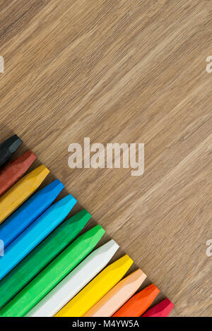 Row of multi colored wax crayons on the wooden board Stock Photo