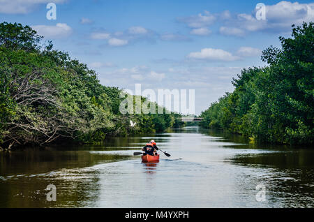 Family rows a red canoe on Biscayne Bay Lagoon at Biscayne National Park in Florida. Stock Photo