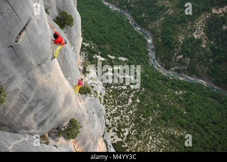 View from above of male and female rock climber climbing rock face, Verdon Gorge, Alpes-de-Haute-Provence, France Stock Photo