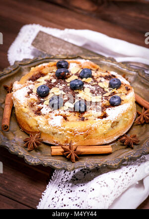 baked round cake with blueberry berries on a copper plate, top view Stock Photo