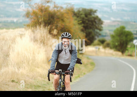 Middle-aged cyclist pedaling bike on road, Pamplona, Navarre, Spain Stock Photo