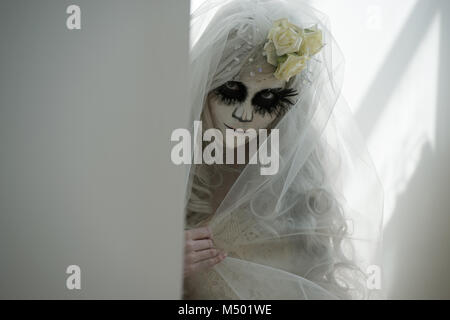 Halloween witch. Beautiful woman wearing santa muerte mask portrait Stock Photo
