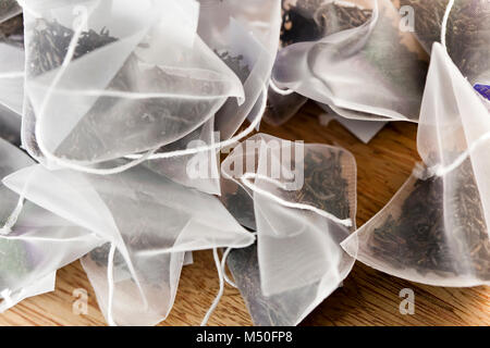 Bags of elite tea in silk fabric packing on a wooden background Stock Photo