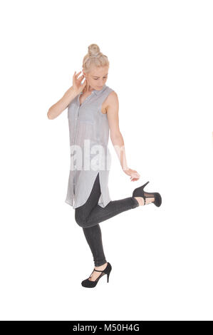 Slim woman standing in profile looking at heel Stock Photo