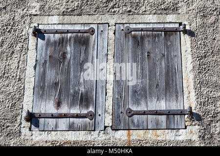 Old wooden shutters with wrought-iron hinges Stock Photo