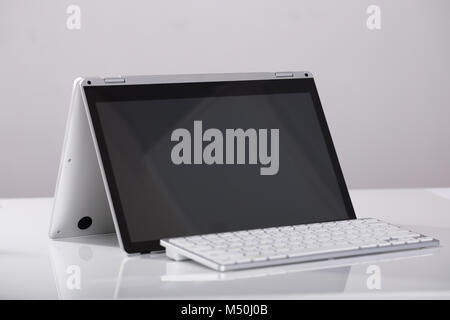 Close-up Of Blank Hybrid Laptop With External Over The White Desk At Workplace Stock Photo