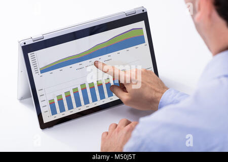 Businessman Analyzing The Chart On The Digital Tablet Over The White Desk At Workplace Stock Photo