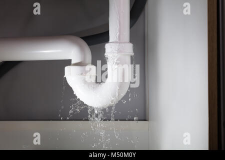 Close-up Of Water Is Leaking From The White Sink Pipe Stock Photo