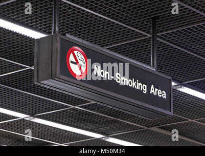 Notification signs for the smoking ban hang from the airport terminal ceiling. Non smoking area. Stock Photo