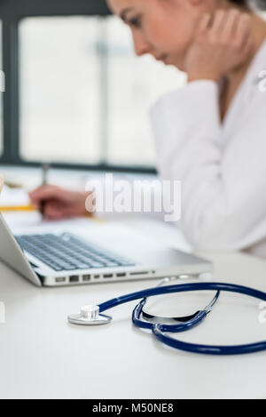 Close-up of the hands of a physician typing on laptop in the off Stock Photo