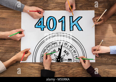 High Angle View Of Group Of People Drawing 401k Pension Plan Stock Photo