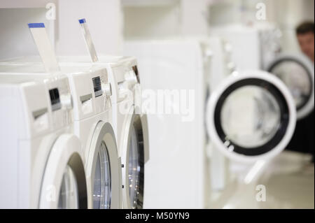 washing machines in appliance store and defocused buyer Stock Photo