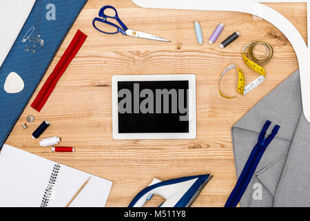 digital tablet and tailoring items on table Stock Photo