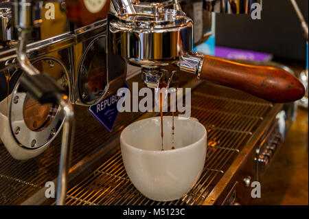 Cup of coffee being made by a professional coffee machine in Ireland. Stock Photo