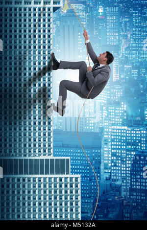 Businessman climbing skyscraper in challenge concept Stock Photo