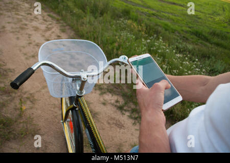 Cyclist using Navigator on your smartphone, search GPS coordinates during Cycling. active lifestyle and modern technology. Stock Photo