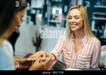 Gorgeous young woman getting her nails done by a manicurist Stock Photo