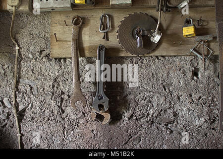 Old tools hanging on nails in a workshop. Stock Photo