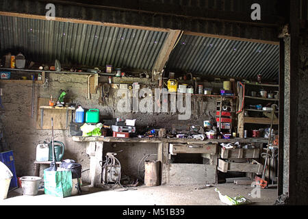 Typical country barn work shop with tools and tins scattered every where. Stock Photo