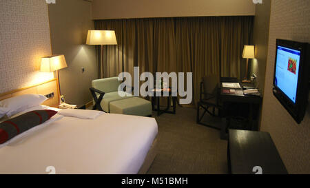 SINGAPORE - APR 1st, 2015: luxury Hotel room with modern interior, a comfortable bed and a chair Stock Photo