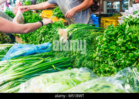 Different fresh vegetables and herbs on outdoor display on market pace of Tel Aviv, Israel. Selective focus, space for text Stock Photo