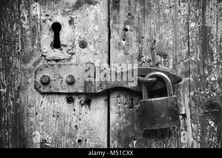 Old lock and rusted keyhole on wooden door, black and white photo Stock Photo