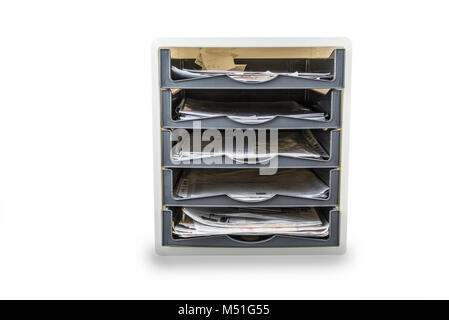 Desktop filing drawers full of papers on the white. Paper office tray. Stock Photo