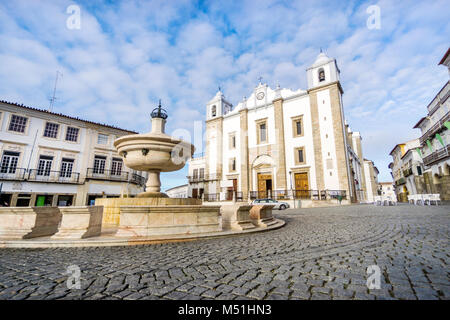 Low-angle skewed shot of a fountain with Saint Anton's Church in the background, featuring a close-up detail of granite pavement, Giraldo Square, Evor Stock Photo