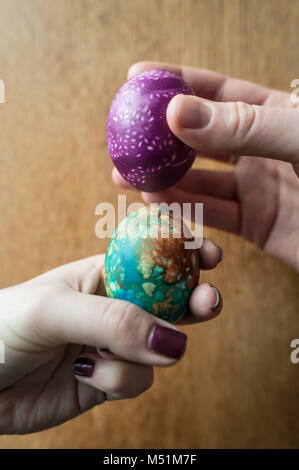 Two hard boiled and decorated easter eggs are knocked together in a traditional game. Stock Photo
