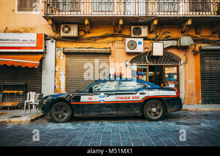 a damaged Dodge Charger Police Pursuit car sits on the roadside in Beirut, Lebanon Stock Photo