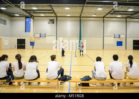 school students playing sports in the indoor sports hall at their school / college Stock Photo