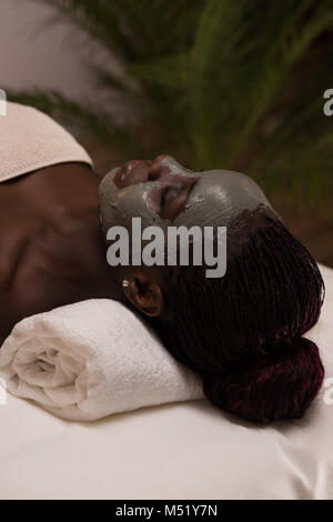 African beauty woman getting mud mask at spa Stock Photo