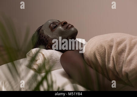 African beauty woman getting mud mask at spa Stock Photo