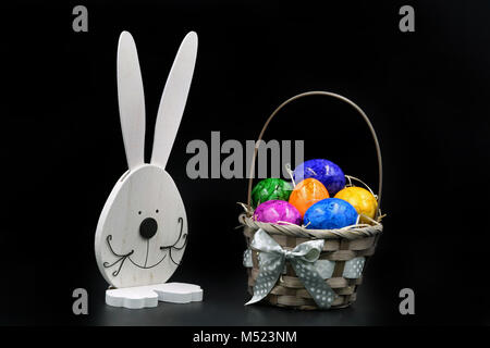 Easter Eggs in Basket with rabbit isolated on black background Stock Photo
