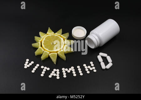 lemon as sun with tablets vitamin D isolated on black Stock Photo
