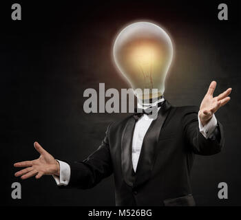 Businessman with lamp head on black background. Welcoming gesture Stock Photo